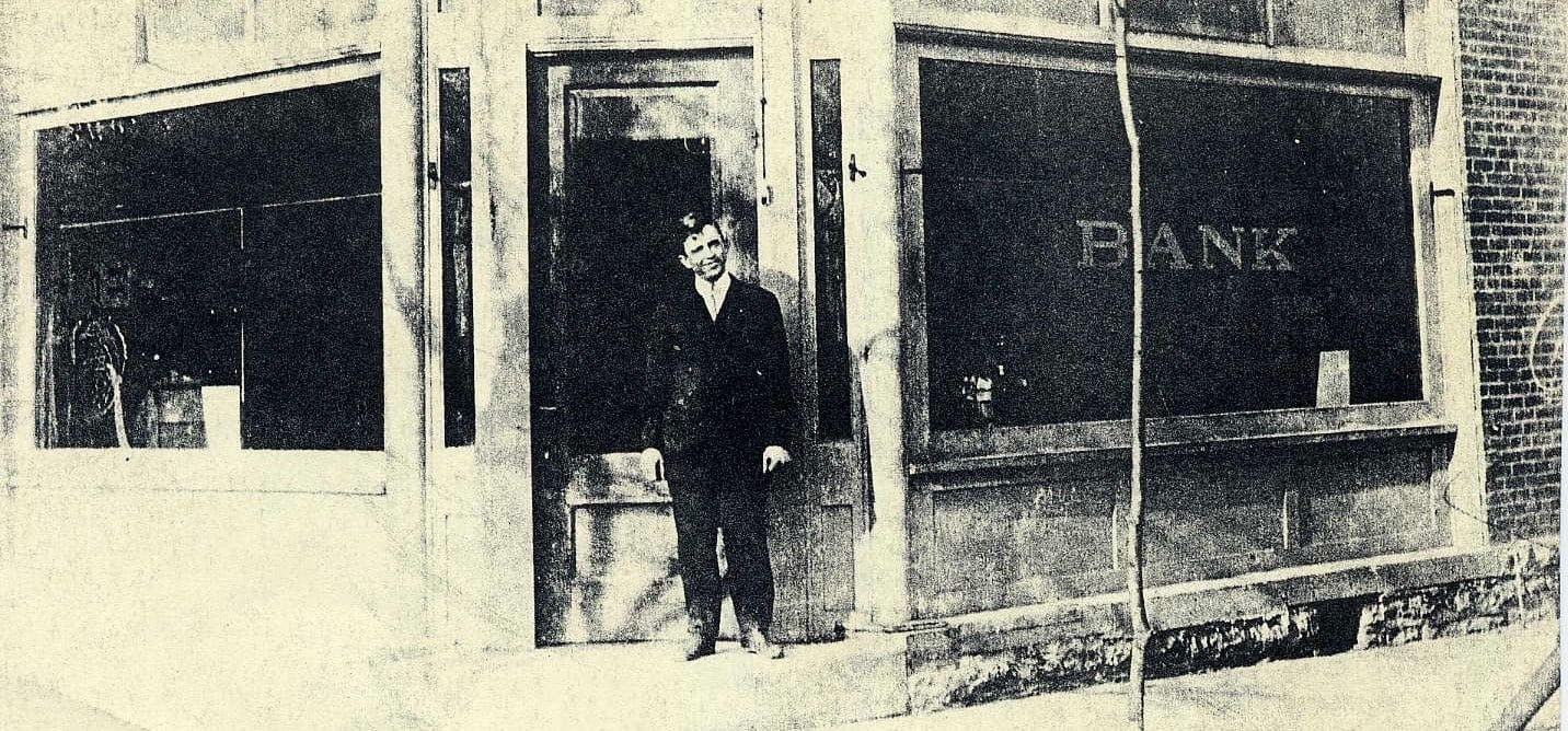 Man standing outside an old bank.